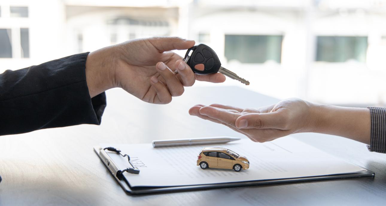 Mano entrega llaves de coche a otra